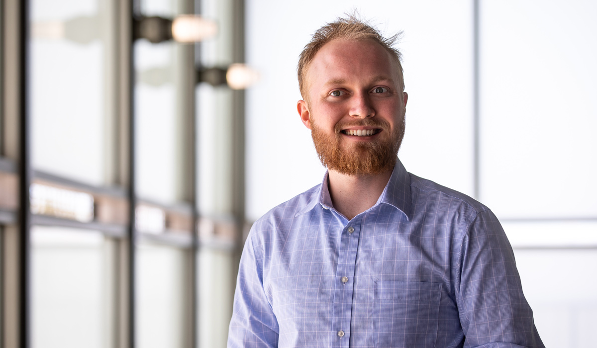 A student in the Master of Liberal Studies program poses for a photo in front of a window.