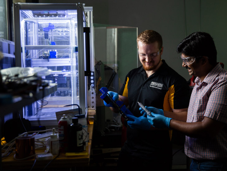 Two engineers working on replacing a cartridge and using a special printer that utilized conductive ink in the Sugar lab.
