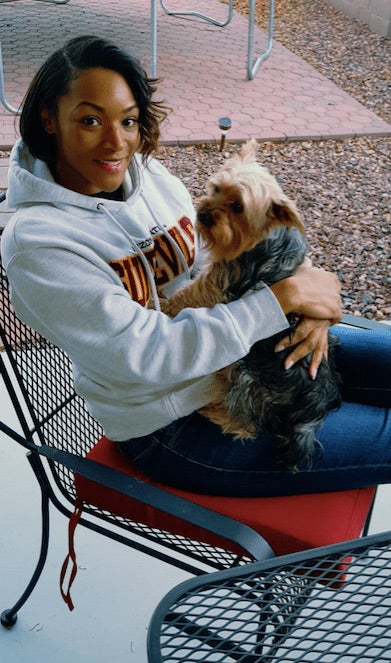 ASU Online student sits in a chair with her dog. 