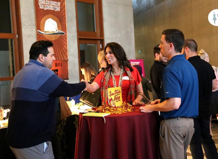 Three ASU Sun Devils meeting in a social environment.