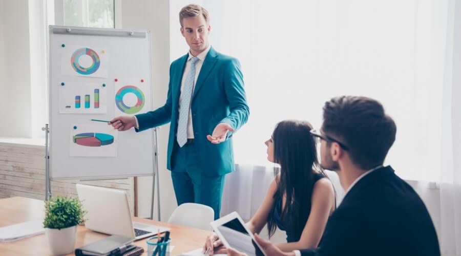 A sales manager reviews graphs with his team.