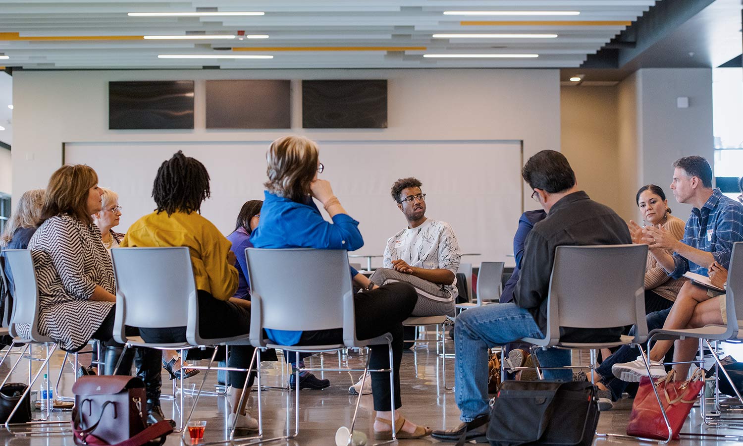A group of sociology students sit in a circle and discuss topics during class.