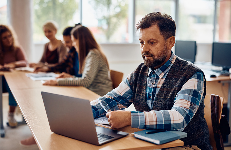 An ASU Online graduate students works on their computer at a library.