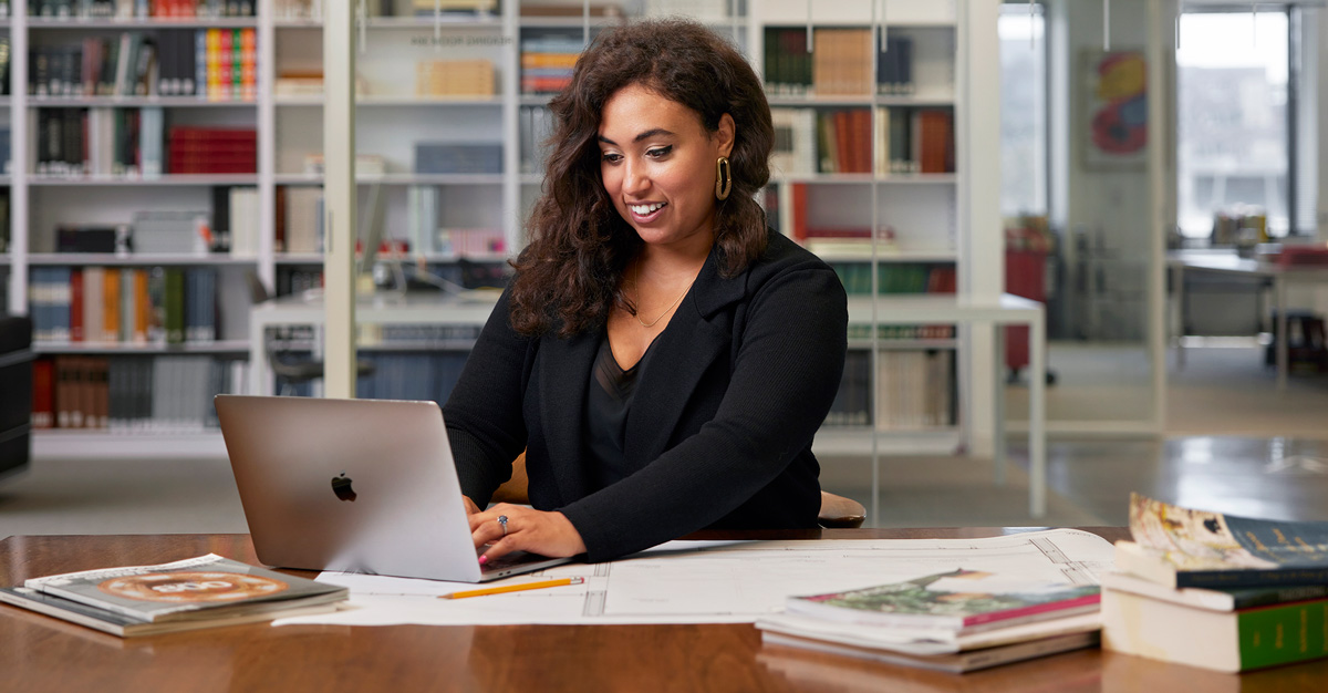 A student in the MLS with an emphasis in health care law and administration types on a laptop.
