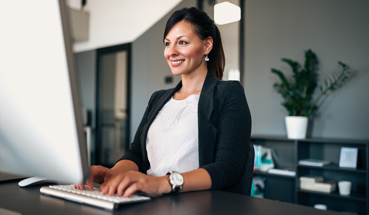  A public health expert sits at a desk typing.
