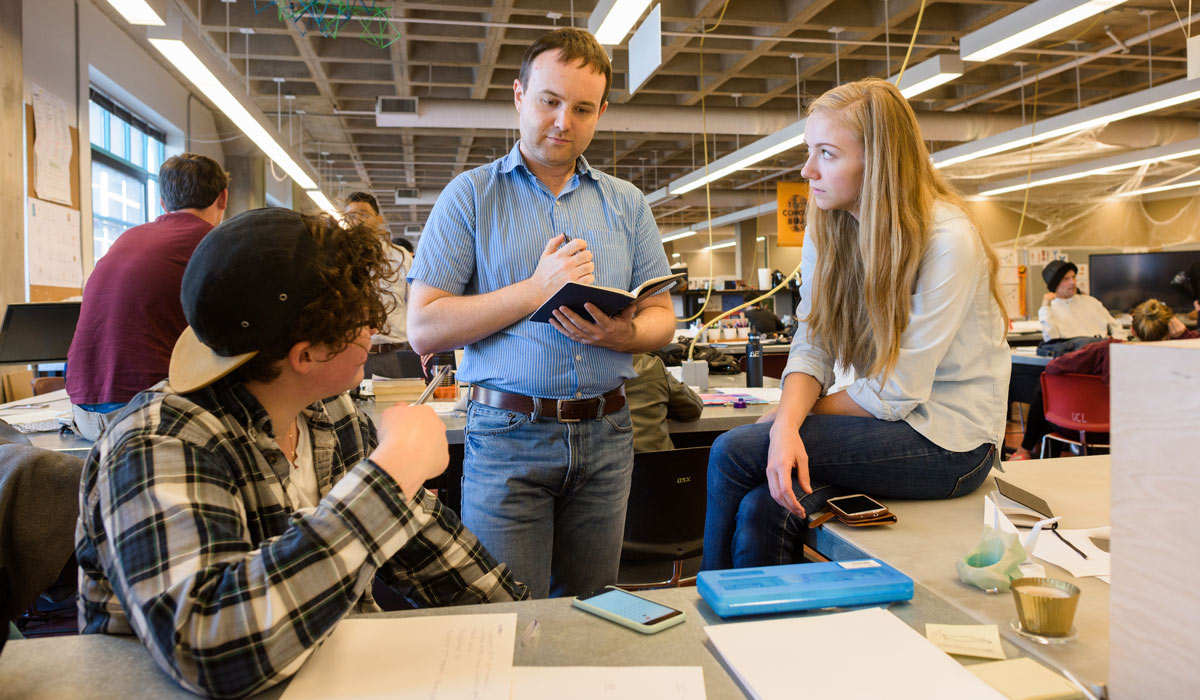 Students in this online sustainability leadership master’s program discuss sustainable practices at a table.