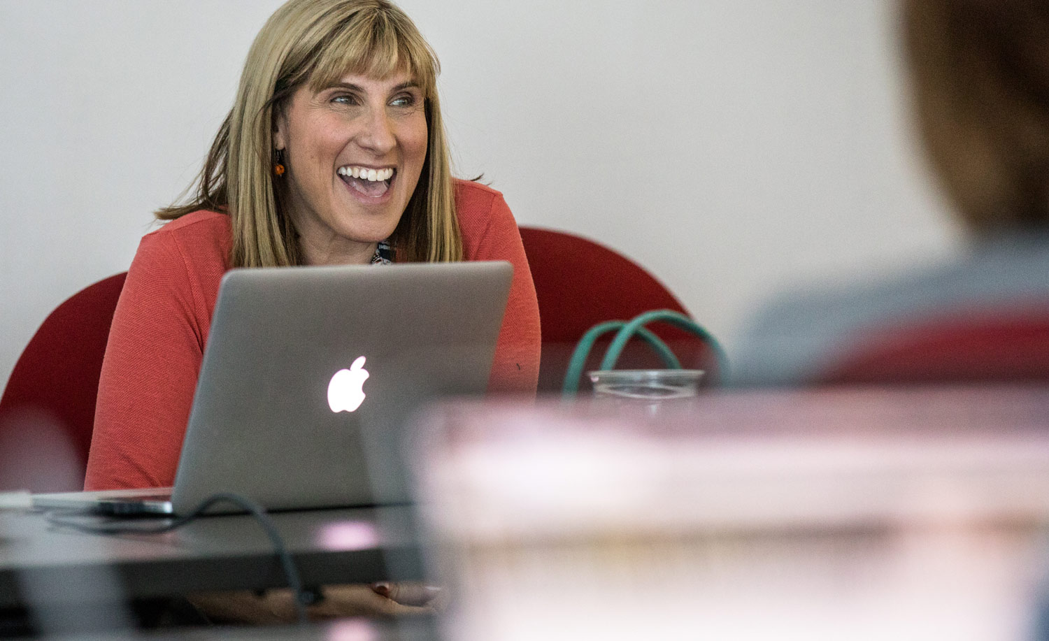 A woman smiles as she meets with a client.