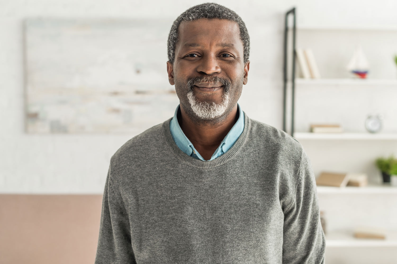 Older African American man smiles cheerfully for a portrait.
