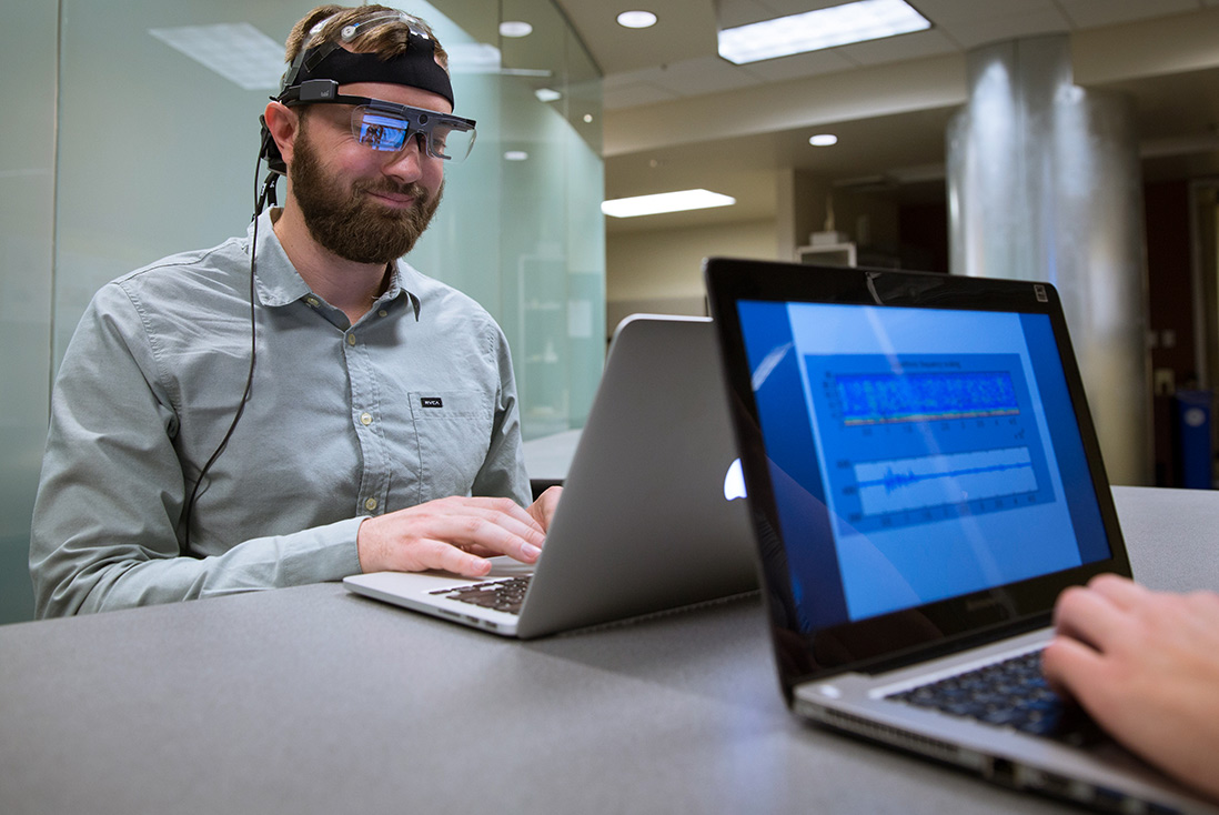 Two industrial engineering master’s students use equipment from a learner and user experience lab, including software and eye-tracking glasses.