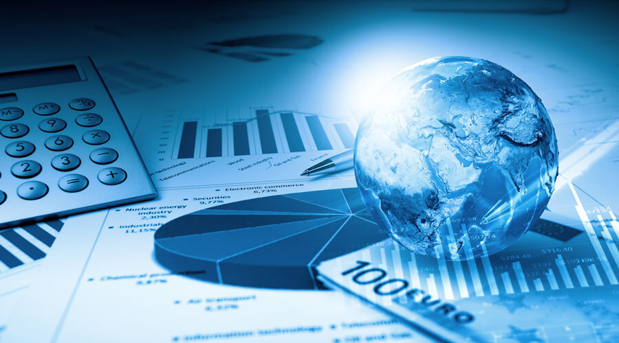A concept image shows a globe sitting on a stack of documents and office supplies, including graphs, a calculator and a pen.