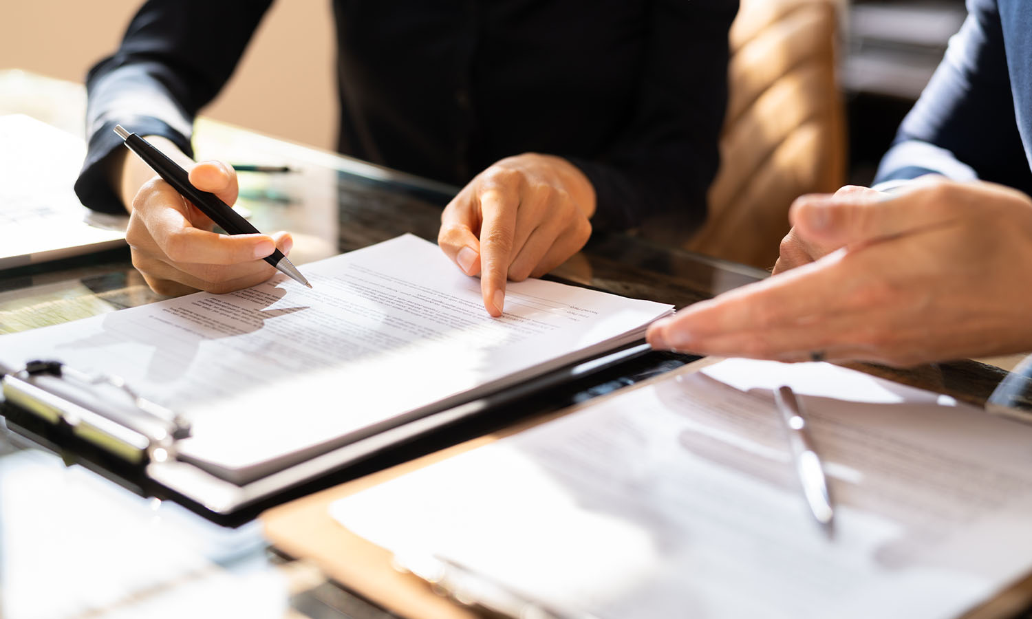 Two individuals review and discuss a legal document at a table, relevant to federal contracting law master's coursework.
