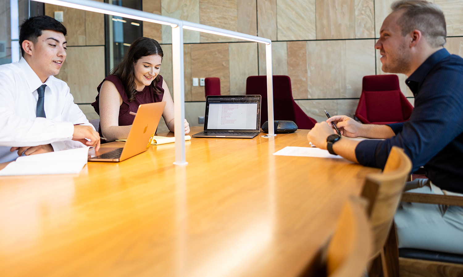 Three project management students collaborate on coursework.